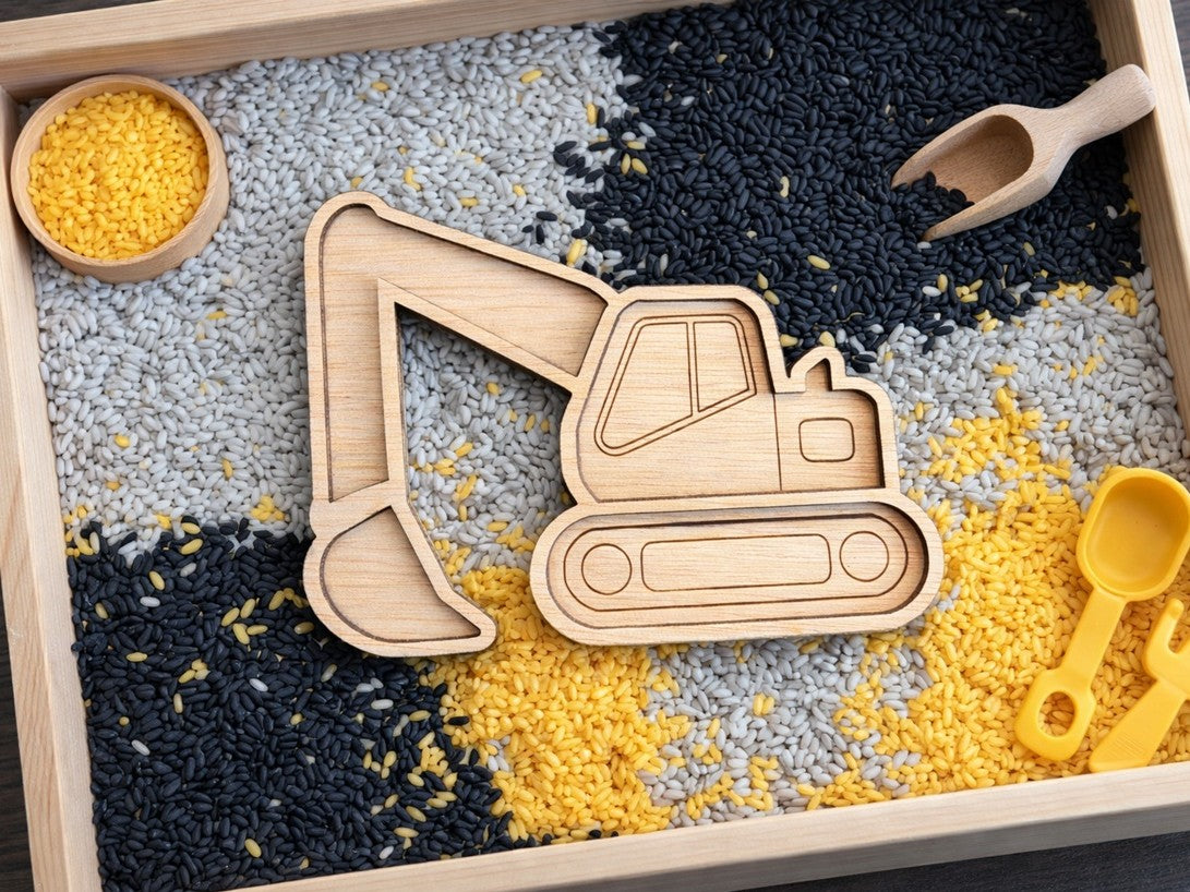 Een foto van 3 houten vulvormen op een eikenhouten tafel. Een watermeloen vorm gevuld met rode sterretjes. Een houten appel vulvorm gevuld met groene wol en een houten citroen vulvorm gevuld met gele speelrijst. 